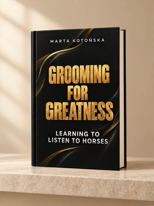 A hardcover book titled 'Grooming for Greatness: Learning to Listen to Horses' by Marta Kotonska, standing upright on a light stone surface against a warm beige background with soft window-shadow lighting.